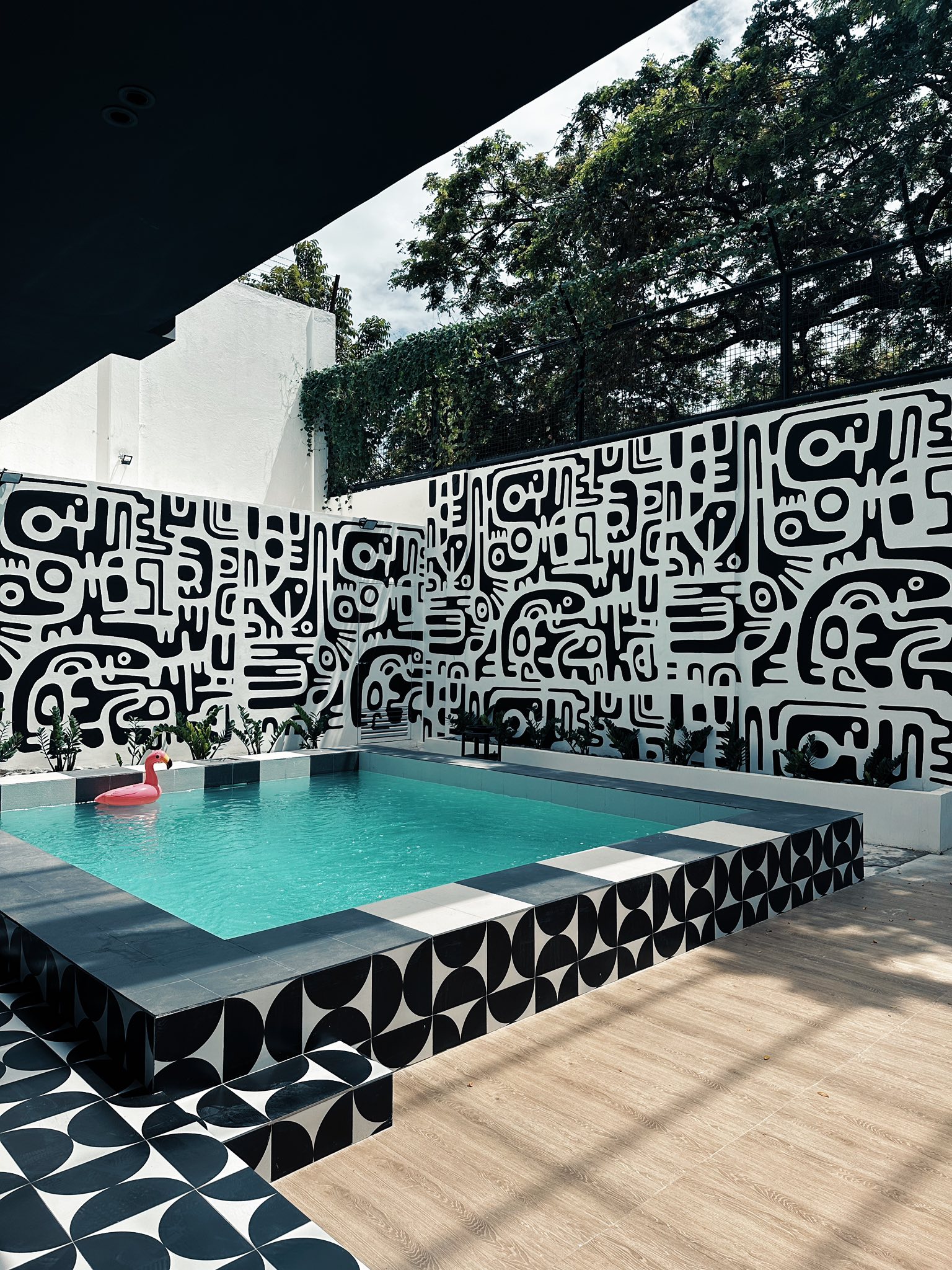 Pool courtyard with bold black and white mural wall at 2nd Home and 3Bu Hostel complex